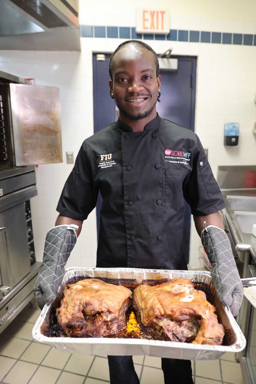 FIU master's student Daniel Marcelin showcasing the pork that was on the menu at SOBEWFF in 2025