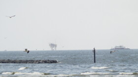 Oil rigs are visible off the coast of Grand Isle, La. 