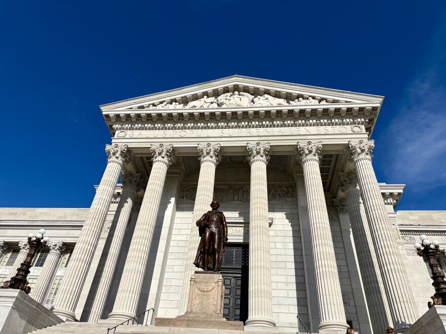 The columns at the front entrance of the Missouri state capitol building. A statue of Thomas Jefferson is centered in the front. 