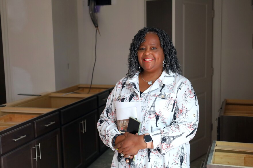 A woman poses inside an unfinished apartment