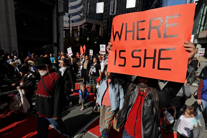 Dennis Willard, of Bellevue, Wash., carries a sign that reads "Where Is She" as he marches in support of missing and murdered indigenous women during a rally to mark Indigenous Peoples' Day in downtown Seattle, on Oct. 14, 2019.