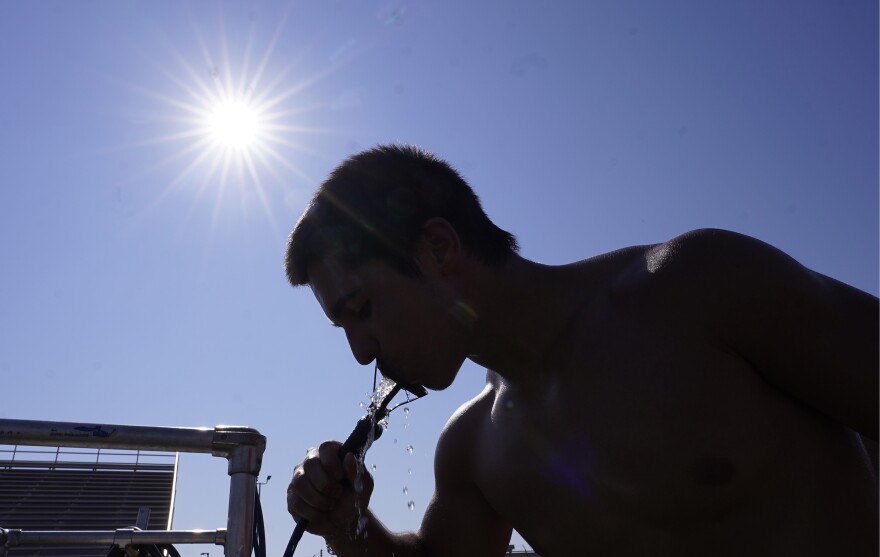 High school senior Areion Coln drinks water after football practice in Richardson, Texas, Monday, July 24, 2023. (AP Photo/LM Otero)