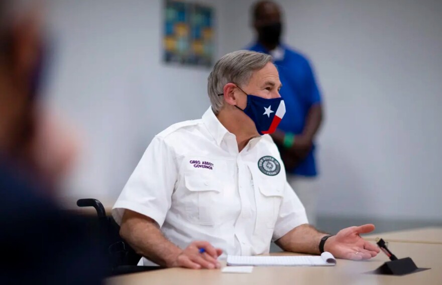Gov. Greg Abbott wears a face mask at a press conference.