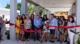Maggie Whitcomb, the founder of the Florida Keys Community Land Trust, cuts the ribbon on the group's first home completed on Big Pine Key.