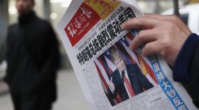A man reads a newspaper with the headline of "U.S. President-elect Donald Trump delivers a mighty shock to America" at a news stand in Beijing on Nov. 10, 2016. (Andy Wong/AP)