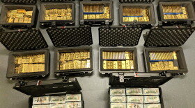 Open boxes full of gold bars and cash.