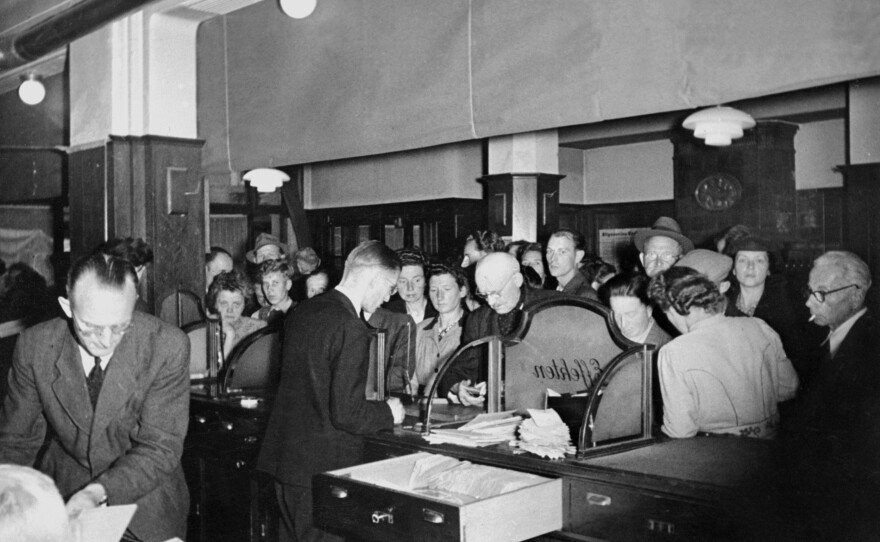 Germans wait to change their pre-World War II currency, the reichsmark, into deutschemarks, which were introduced in 1948 in western Germany. The deutschemark was later replaced by the euro.