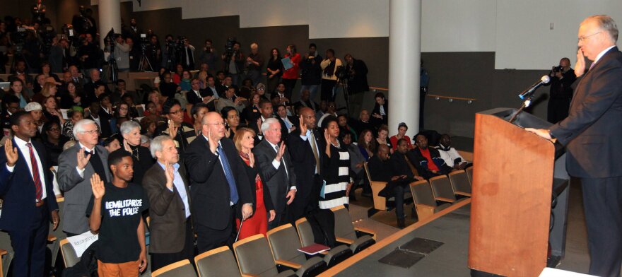 Missouri Gov. Jay Nixon, right, swears in the members of the commission. Nov. 19