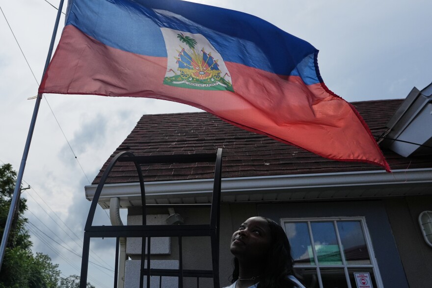 Patricia Grace Louis-Jacques, a nursing student who has close Haitian family members and friends affected by the end of TPS, poses for a photo outside the Caribbean Creole Café in Salisbury, Md., Sunday, Aug. 2, 2026. (AP Photo/Luis Andres Henao)