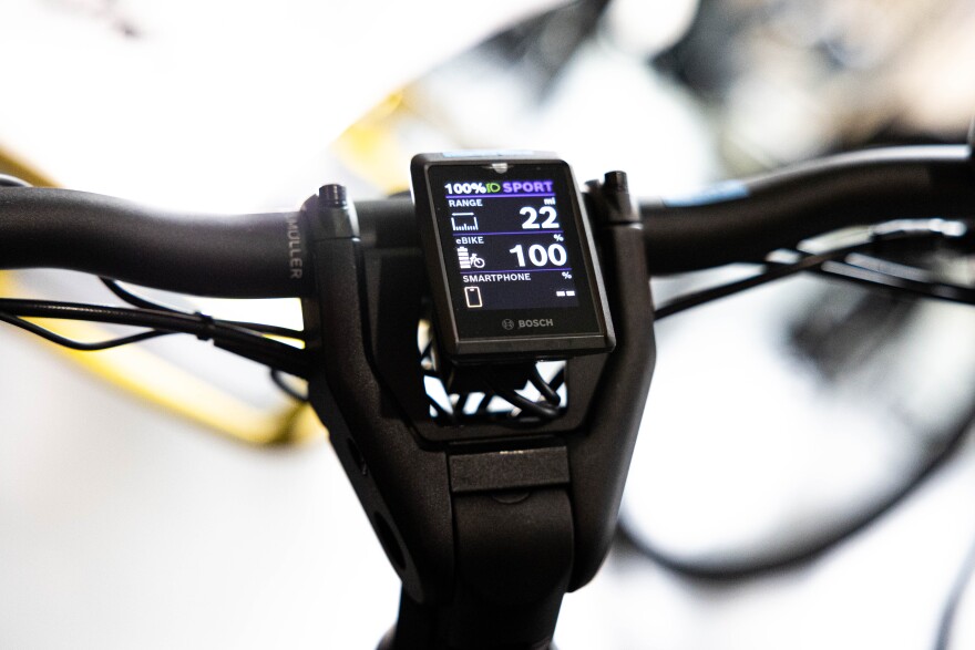 An e-bike Monitor displaying range, battery percentage, and a smartphone battery percentage