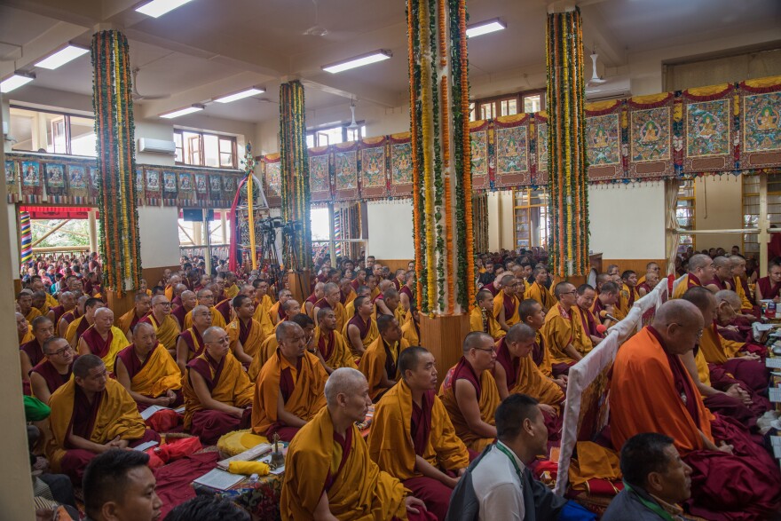 Buddhist monks listen to the Tibetan spiritual leader preach from atop a throne in Dharamsala, India, in September.