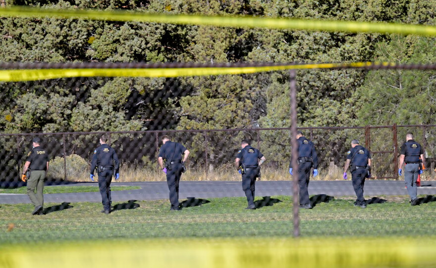 Law enforcement crews search the field behind Silver Rail Elementary School, in Bend, Ore., Oct. 15, 2026.
