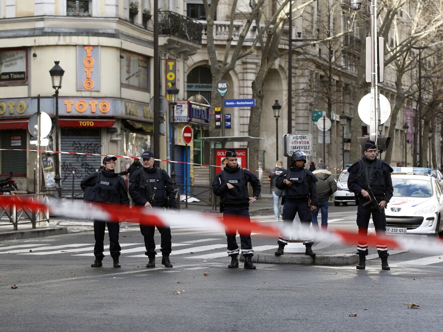 Police stand on patrol in the north of Paris on Thursday, as the city remained on edge after a man attempted to gain access to a police station while brandishing a knife. Police shot the man, who later died.