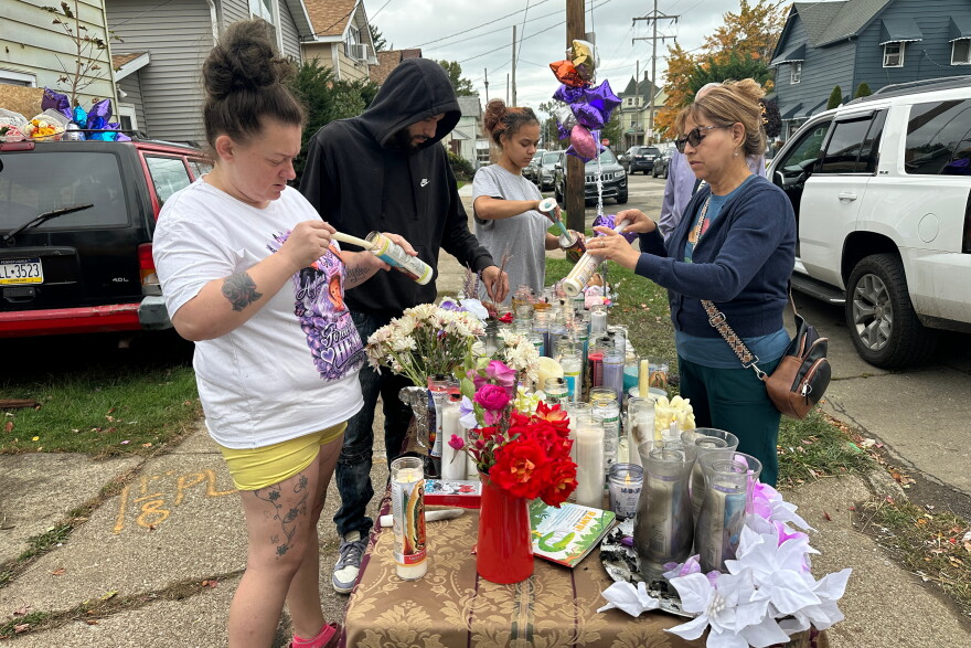 People gather at a memorial in Erie, Pa., Sunday, Oct. 11, 2026, outside the home where authorities say a gunman killed several people before killing himself on Oct. 9. 