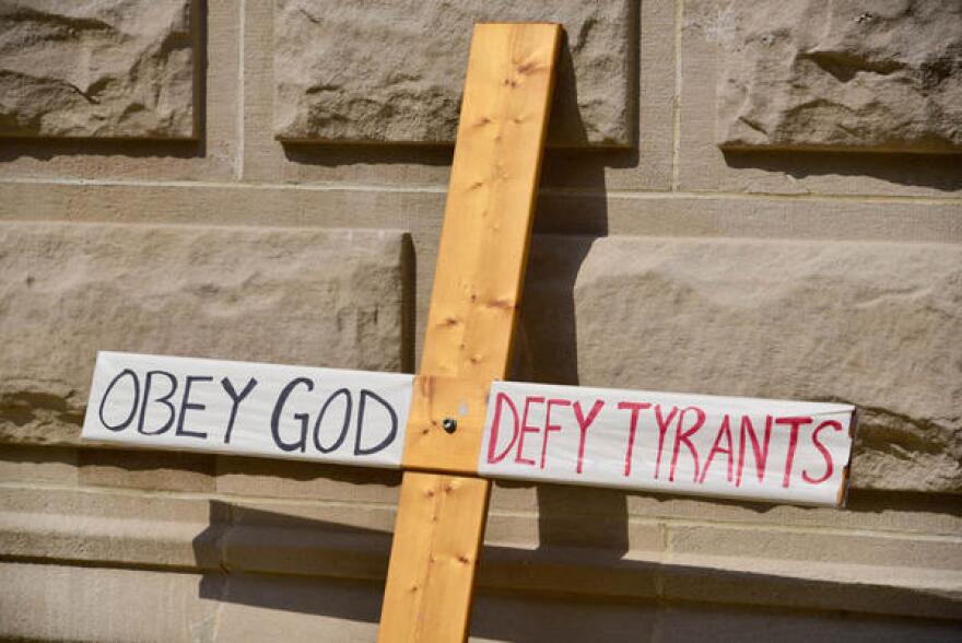 A cross carried at a protest on the lawn of the Indiana Statehouse in opposition to vaccination requirements from government. (Justin Hicks/IPB News)