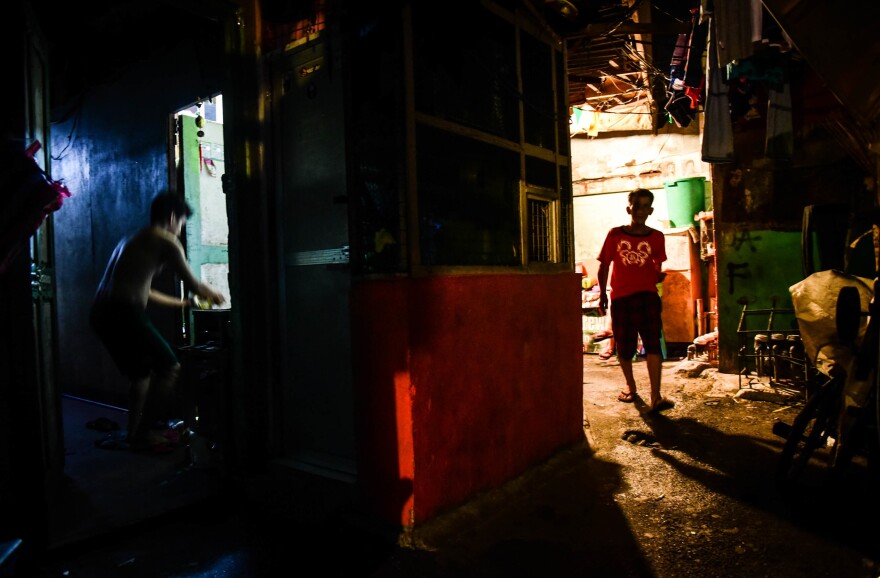 A man walks down a small street in the Arellano district of Manila.