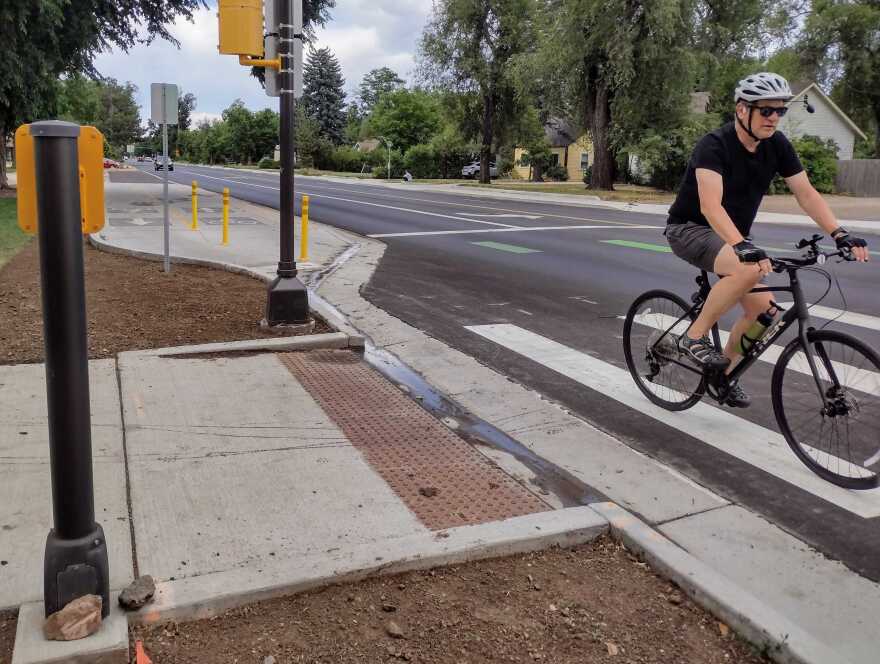 A man rides a bicycle through an intersection.