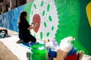Muralist and musician Erin Tobey at work on the Science of Scale mural on the east side of The Kirkwood Apartments, 315 W Kirkwood Ave in Bloomington