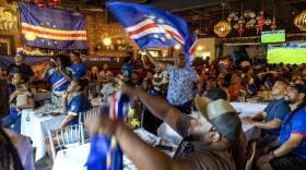 A man waves a Cabo Verde flag as fans watch the World Cup game against Spain at the Restaurante Cesaria in Dorchester.  (Robin Lubbock/WBUR)