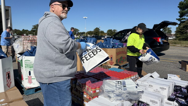 Pastor Joe McGourn with the Alive Dream Center in Suffolk and Dana Carhart with the Foodbank of Southeastern Virginia and the Eastern Shore bag pantry staples for the food distribution event Oct. 17.