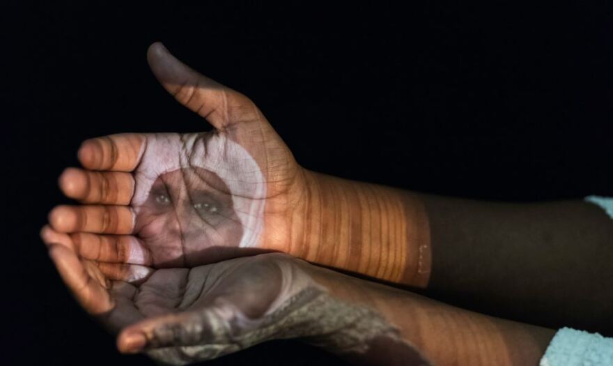 Samantha Richardson with projection of Sadiya Omar, a Somalian refugee.