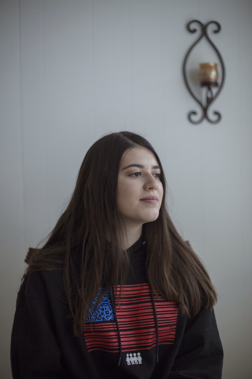 Evelyn Schentrup wears a sweatshirt designed by students involved with the March for Our Lives organization. Since the shooting and moving with her family across the country, Evelyn has struggled with anxiety and enrolled in online high school classes.