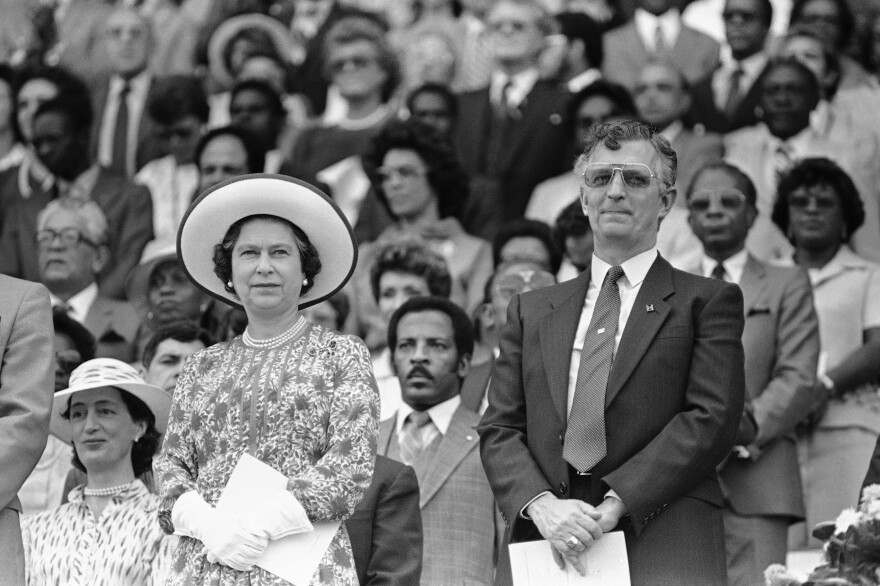 Queen Elizabeth II, left, stands on the reviewing stand alongside Jamaican Prime Minister Edward Seaga during "Jamaica Salute" pageant in the National Stadium in Kingston, Jamaica on Monday, Feb. 17, 1983. Seaga enjoys great support from the western powers and includes President Reagan among his closest supporters. (AP Photo/Kathy Willens)