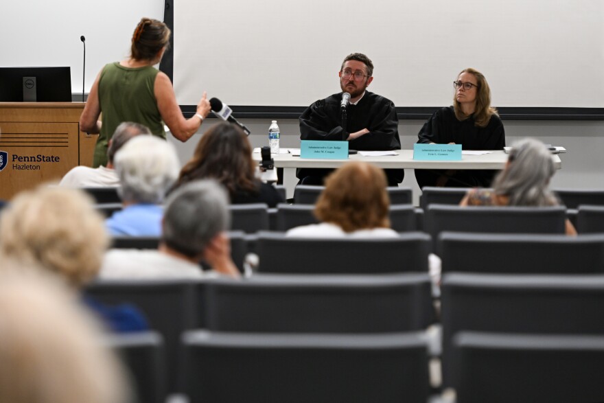 Administrative Law Judges John Coogan and Erin Gannon listen to testimony from Marguerite Woelfel on Phase I of PPL Electric Utilities' proposed Sugarloaf Transmission Project.