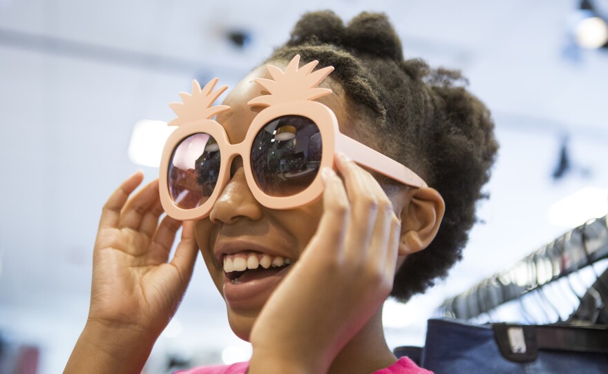 Karisma Clark tries on sunglasses while her mom Ayeisha Owens and sister Kaiden Clark shop for some last minute back-to-school clothes on Saturday, August 18, 2018.