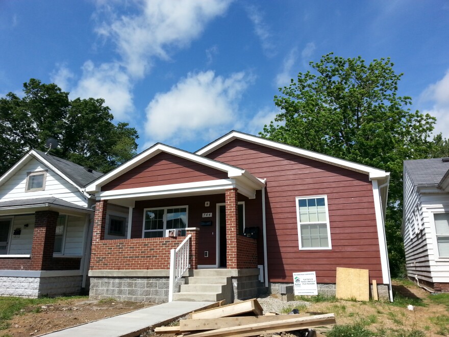 Houses are pictured next to each other. Some boards and other construction materials are visible.