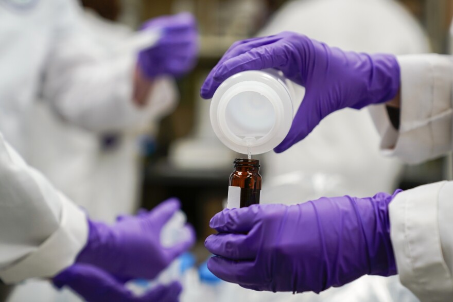 FILE - Eva Stebel, water researcher, pours a water sample into a smaller glass container for experimentation as part of drinking water and PFAS research at the U.S. Environmental Protection Agency Center For Environmental Solutions and Emergency Response, Feb. 16, 2023, in Cincinnati.