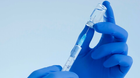 Doctor hands holding a vaccine bottle and syringe,beginning of worldwide mass vaccination for coronavirus COVID-19,influenza or flu,world immunization concept. Selective focus