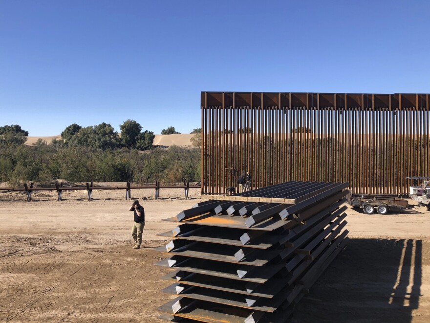 People work at a portion of border wall which is under construction in Yuma, Ariz. Illegal border crossings have plummeted as the Trump administration has extended a policy to make asylum seekers wait in Mexico for court hearings in the U.S.