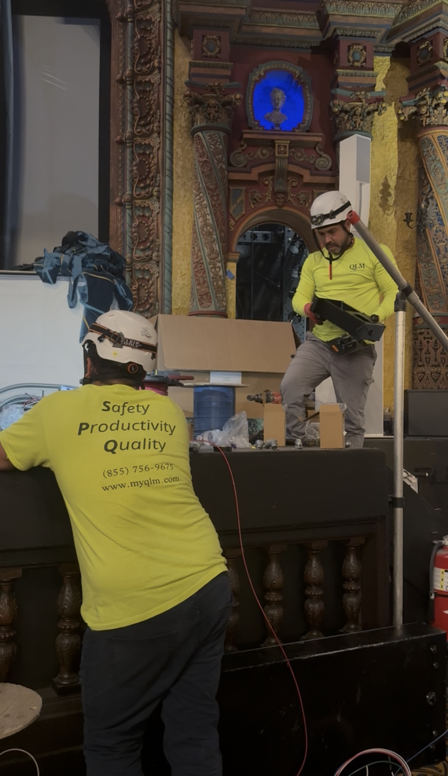 Workers in hardhats tweak the electrical wiring in the Tampa Theatre's Duncan Auditorium ahead of its grand reopening on Oct. 10.