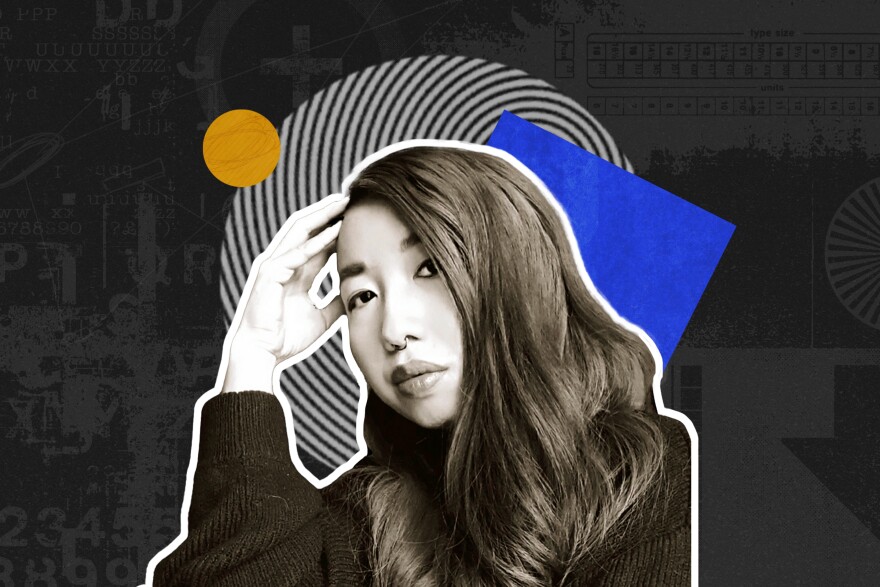 Muriel Leung sits with her head resting on her hand, in front of colorful cutouts