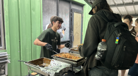 Carson Lokey helps serve food during St. Francis House’s World Homeless Day event on Oct. 10.