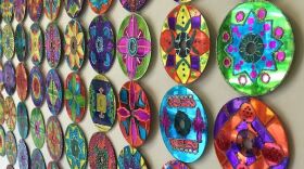 CDs, all colorfully decorated, arranged on a wall