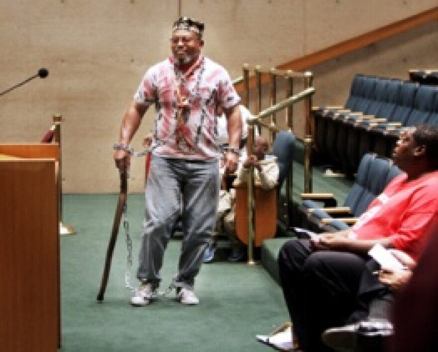Ozumba Lnuk-X with his trademark plastic shackles and cane.