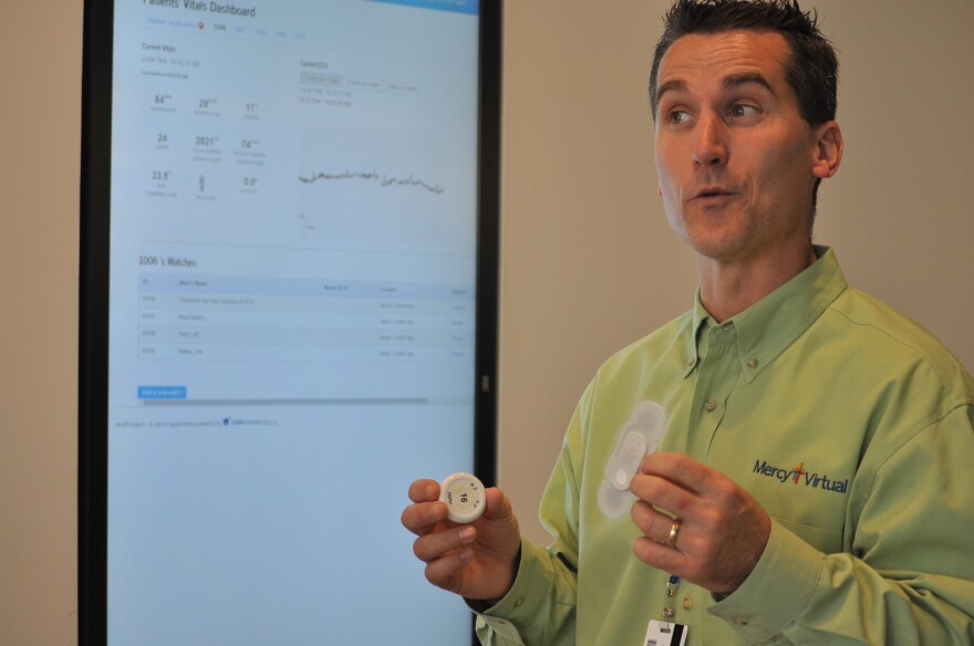 Mark Saxon directs SafeWatch, a virtual care program for intensive care units. Here, he demonstrates two different heart rate monitors used by their program to keep track of patients’ vital signs from afar.