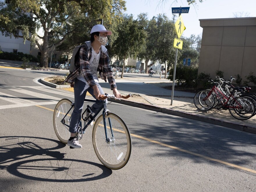 A bicyclist at UC Davis wears a mask on Friday, Feb. 4, 2022.