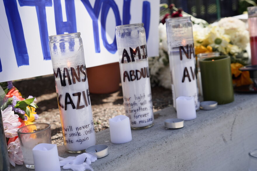 FILE - Candles with victim's names written on them are placed outside the Islamic Center of San Diego, in the aftermath of a shooting, on May 20, 2026, in San Diego.