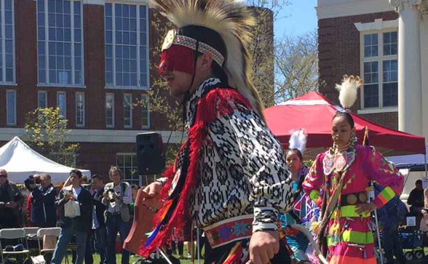  A man in full regalia dances on Amherst Common