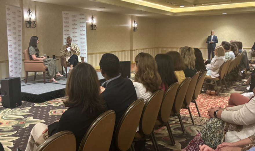Republican Attorney General Daniel Cameron watches on as his wife, Makenze, speaks at a Moms for Cameron event.