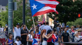 A man spins a Puerto Rican flag during the Puerto Rican parade and festival on Saturday, Aug. 2, 2025, in Rochester.