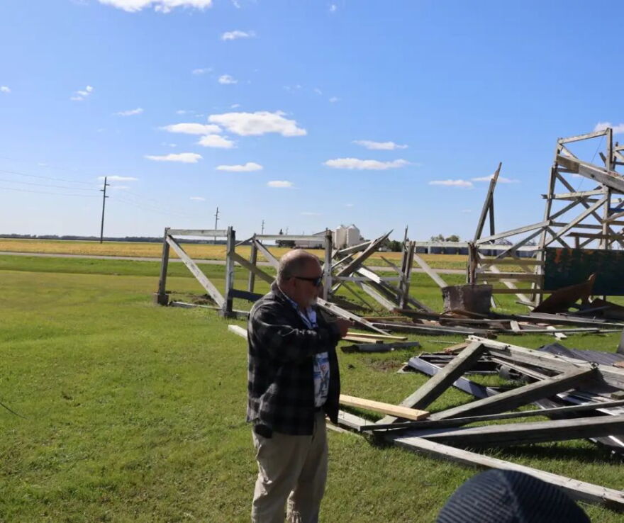 Steve Novak points to the wreckage that used to be the drive-in's screen | MPR News