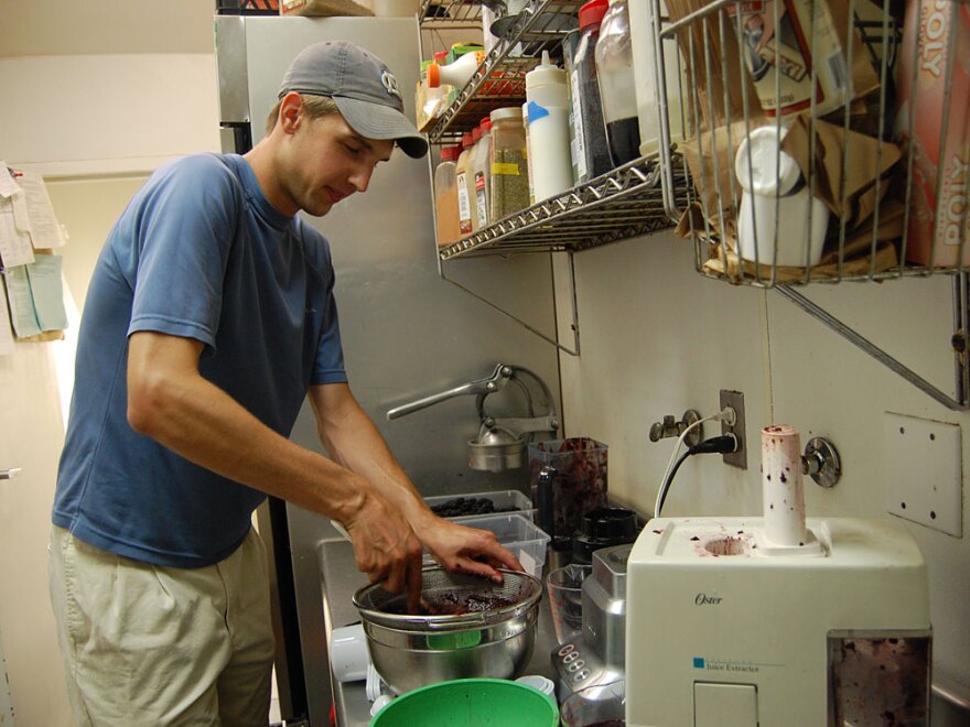 Brian Sykora presses blackberries through a sieve for blackberry and cream ice pops. Pleasant Pops currently rents kitchen space at a cafe for two hours a week.