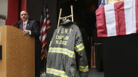  In this Sunday Sept. 11, 2011 file photo, the bunker coat and helmet worn by FDNY Chaplain Mychal Judge are displayed as City of New York Fire Commissioner Salvatore J. Cassano speaks at the New York City Fire Museum in New York during a memorial ceremony for the 343 members of the FDNY who lost their lives in the World Trade Center attacks. The bunker coat and helmet worn by Father Judge on Sept. 11, 2001, were dedicated to the museum during the service. (AP Photo/Tina Fineberg, File)