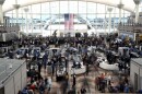 Passengers wait in a security line at Denver International Airport on Feb. 22, 2023. Passengers had to use an emergency slide to evacuate a smoking American Airlines jet at Denver International Airport. The Federal Aviation Administration says the Boeing 737 MAX 8 reported a "possible landing gear incident" during its departure for Miami on Saturday.