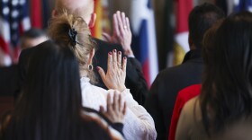 New citizens pledge take their citizenship oath during the naturalization ceremony Friday, Dec. 6, 2024, in Dallas City Hall.