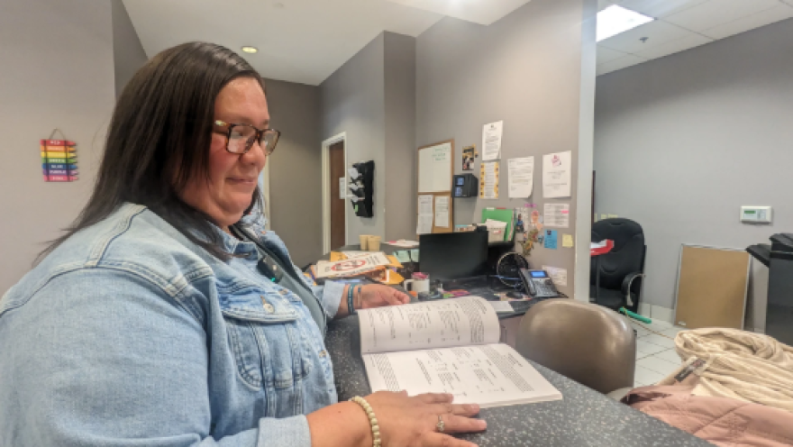 Tina Hickman, of Choctaw, Mississippi, flips through the course catalog for Bay Mills Community College, the tribal college she attended to earn her bachelor’s degree.